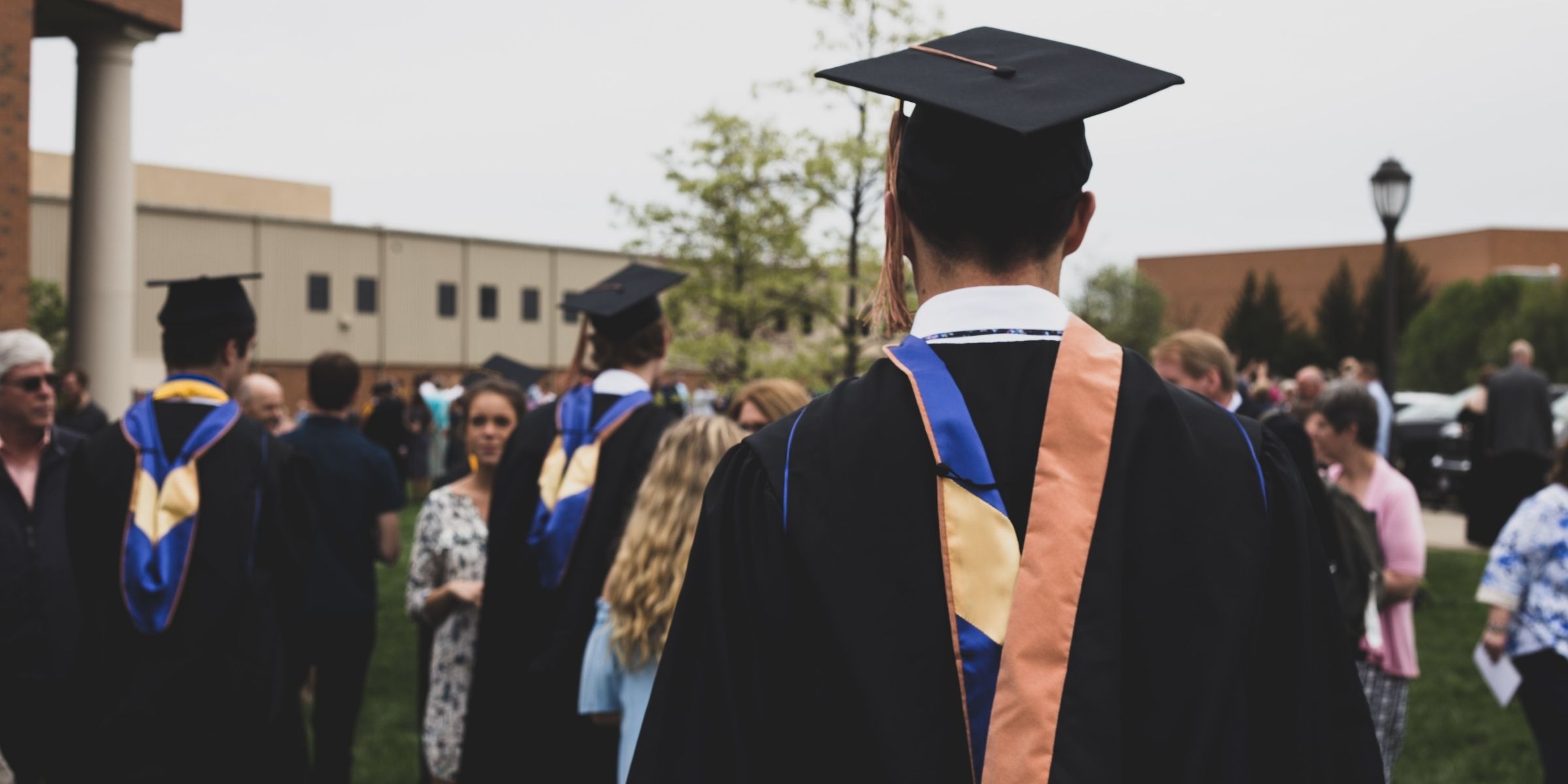 a group of students mingling while wearing graduations caps and gowns