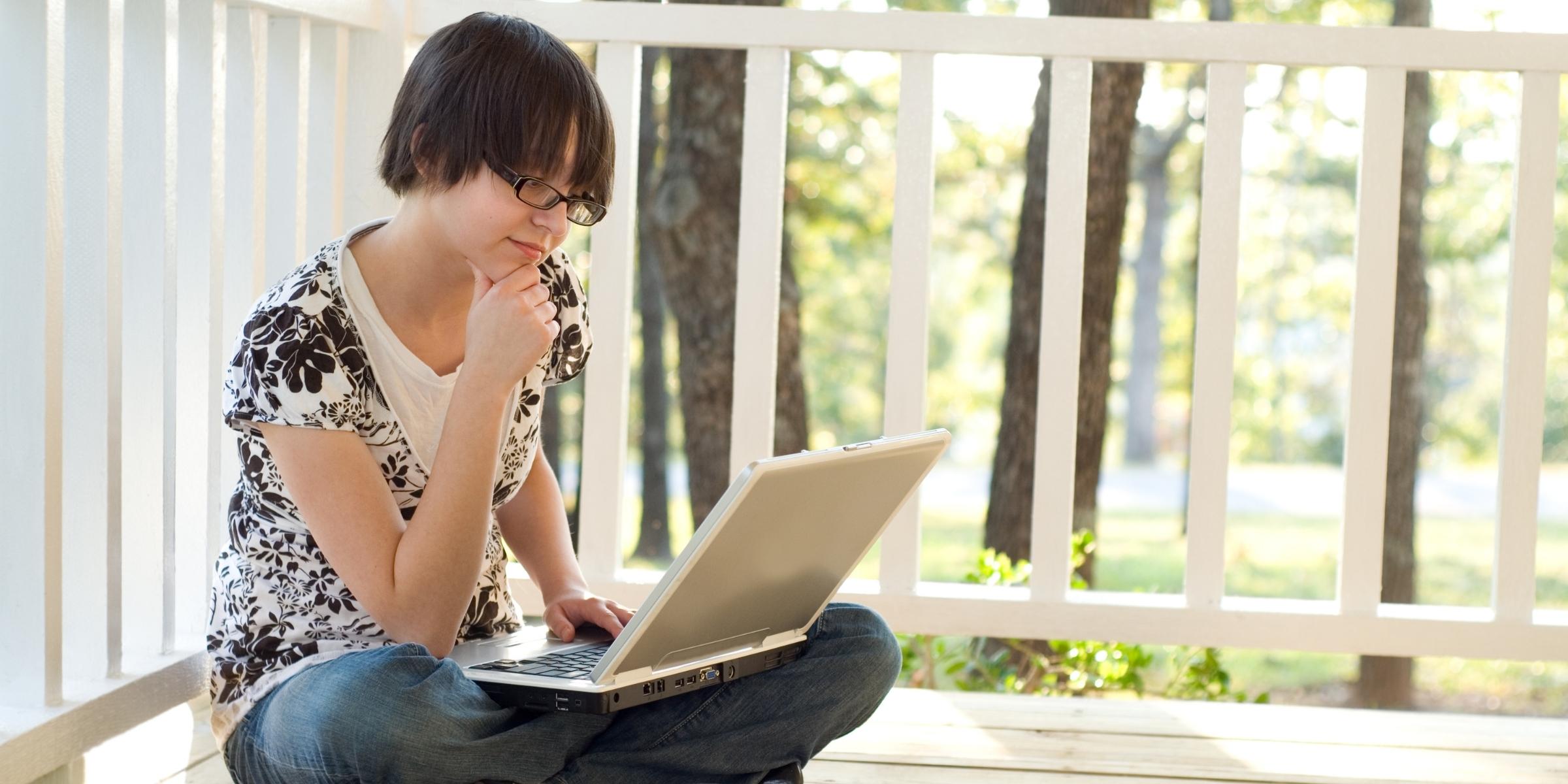 a student sitting down across from an open laptop