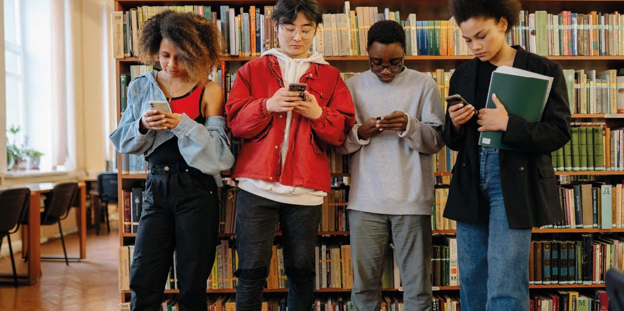 students texting in a library